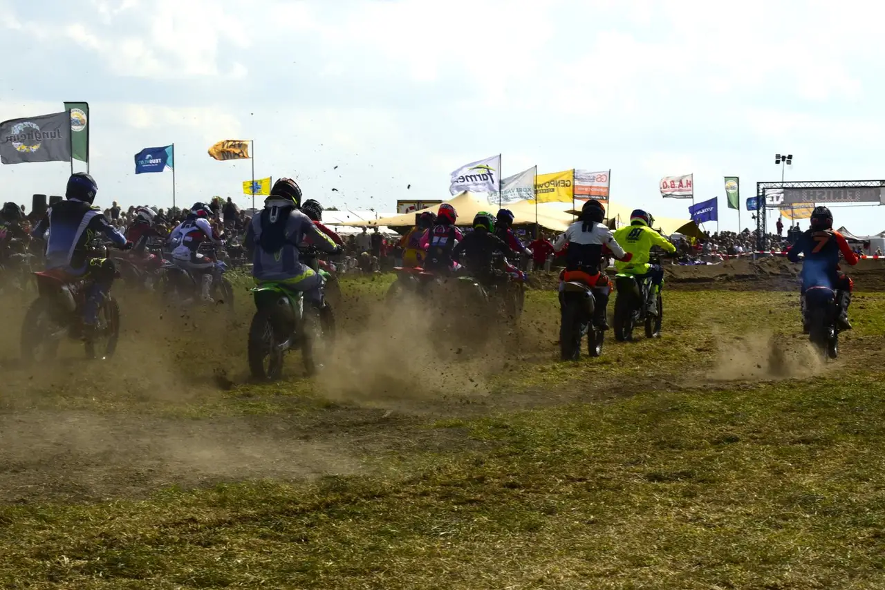 Motorcrossers rijden samen de eerste bocht in